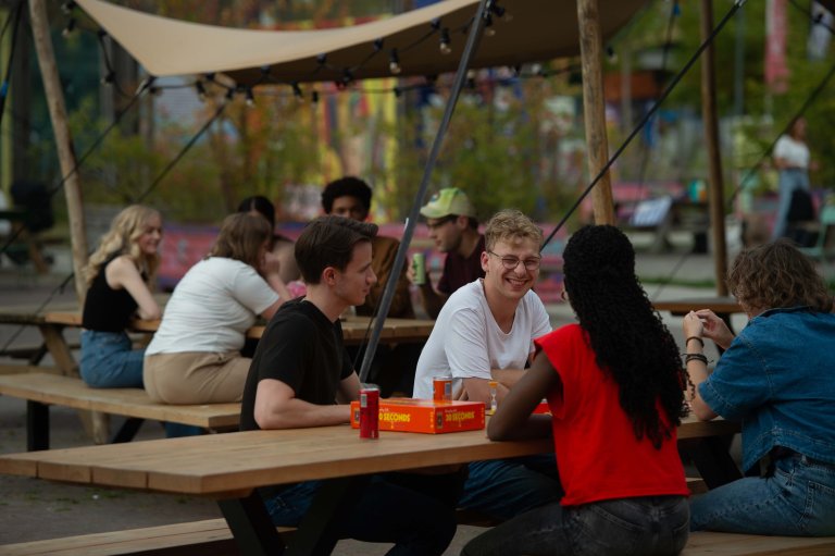 Wat mensen aan een tafel die gezellig aan het kletsen zijn