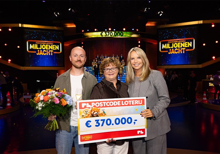 Mevrouw en meneer staan naast Linda in de studio van Miljoenenjacht en houden een grote geldcheque omhoog van 370 duizend euro